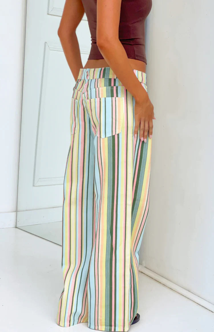 Rear side view of multi stripe low rise jeans with back pockets and pastel blue pink yellow green vertical stripes
