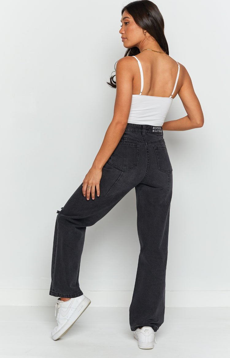 Faded black wash wide leg denim jeans with a high waist and ripped knee