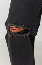 High waisted black wash wide leg jeans with distressed ripped knees and a faded denim texture