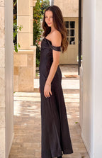 Side view of a black off-shoulder maxi dress with a fitted bodice and flowy skirt