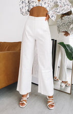 Flowing white linen pants featuring a high waist and a relaxed wide-leg cut