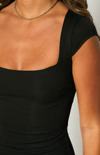 Black mini dress with a square neckline, short cap sleeves, and fitted silhouette