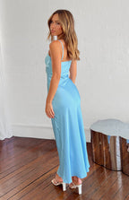 Side view of a blue satin maxi dress with thin spaghetti straps and a flowing skirt