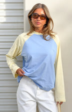 Front view of a blue and yellow contrast raglan sleeve top with a relaxed fit
