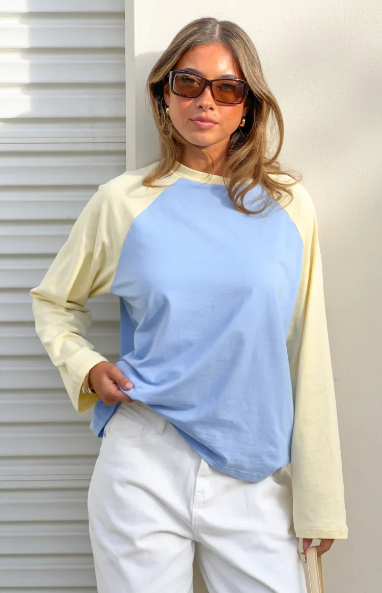 Front view of a blue and yellow contrast raglan sleeve top with a relaxed fit