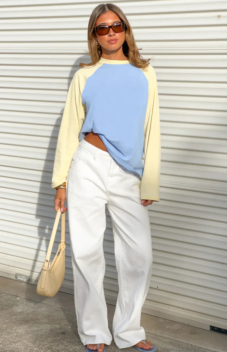 Front view of a blue and yellow contrast raglan sleeve top with a relaxed fit and slightly cropped front